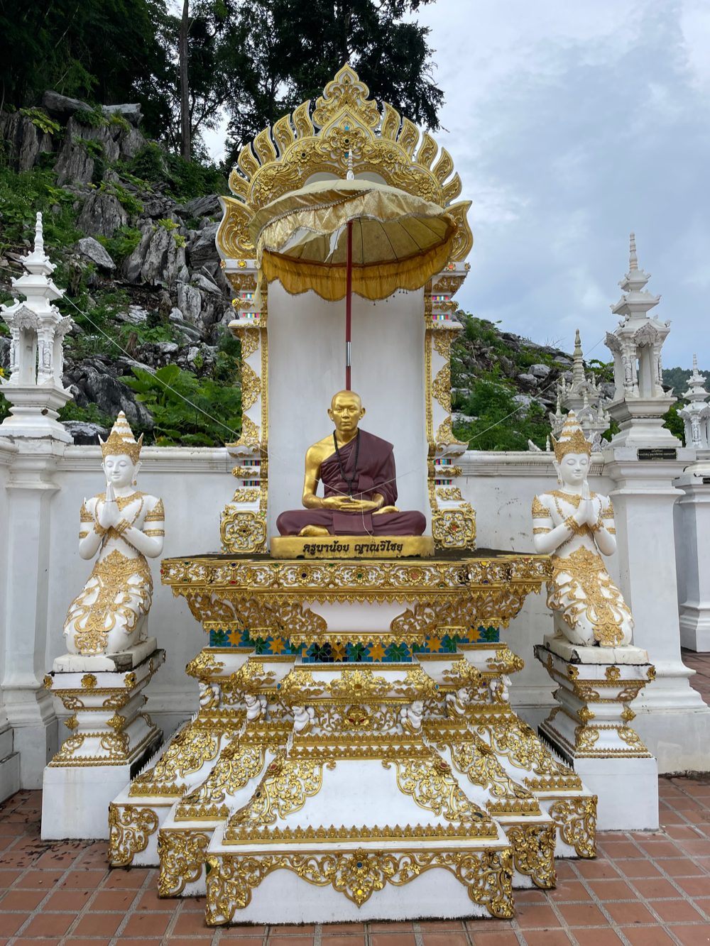 รูปเหมือนครูบาน้อยปิดทองบนฐานสีขาว